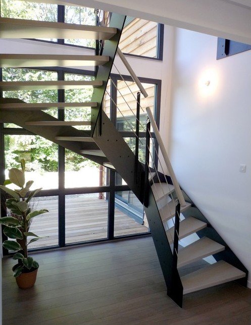 Escalier moderne lÃ©ger devant bais vitrÃ© main coutante et marches bois